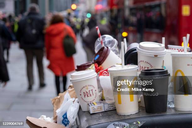 Coffee and soft drinks cups from some of the major take away food and drinks companies piled up on top of an overflowing street rubbish bin in the...