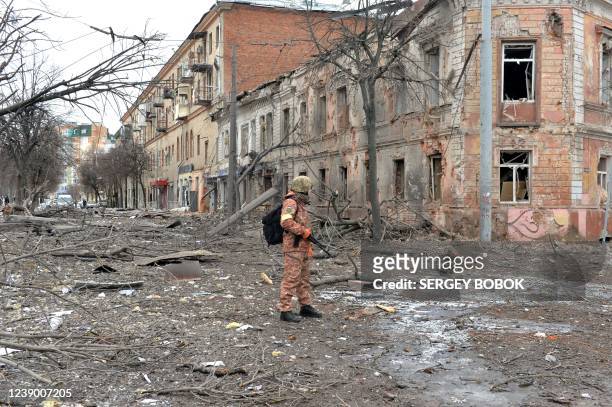 Member of the Ukrainian Territorial Defence Forces looks at destructions following a shelling in Ukraine's second-biggest city of Kharkiv on March 7,...