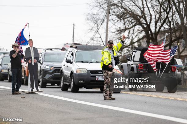 Demonstrator carries a cardboard cutout of former US President Donald Trump as others depart Hagerstown Speedway in Hagerstown, Maryland, on March 7...