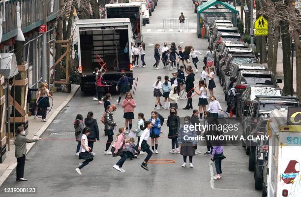 Children play jump-rope on the street off 5th Avenue in New York City on March 7, 2022. - New York City has dropped several Covid-19 safety...