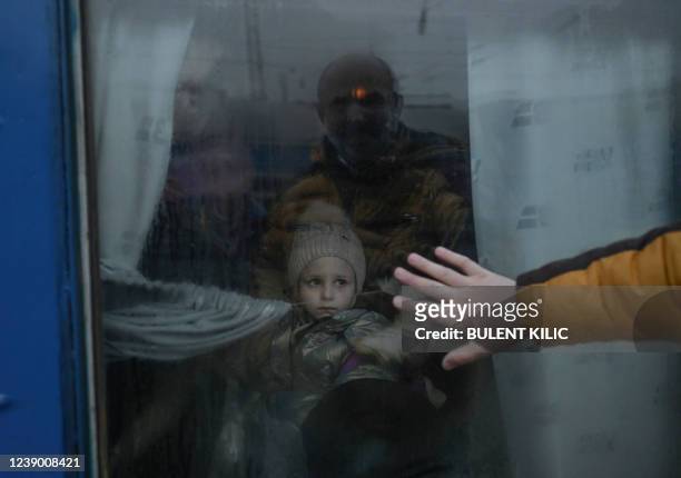 Father puts his hand on the window as he says goodbye to his daughter in front of an evacuation train at the central train station in Odessa on March...