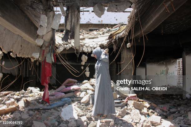 Director of the Women's Research and Training Center at Aden University Huda Ali Alawi walks on rubble of a war-destoyed building at the campus in...