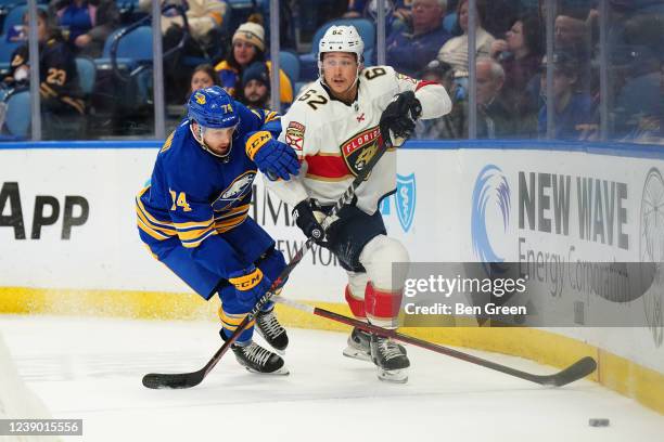 Rasmus Asplund of the Buffalo Sabres and Brandon Montour of the Florida Panthers battle for the puck during an NHL game on March 7, 2022 at KeyBank...