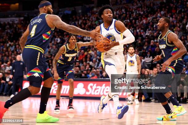 Jonathan Kuminga of the Golden State Warriors drives past DeMarcus Cousins of the Denver Nuggets at Ball Arena on March 7, 2022 in Denver, Colorado....