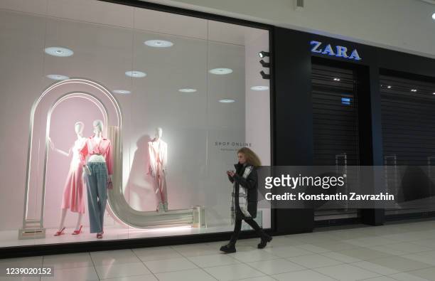 Shopper walks nearby the Zara retail store, which suspended its activity in Russia, on March 7, 2022 in Moscow, Russia. Puma, Bershka, Pull&Bear,...