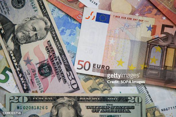 This photo illustration displays a collection of fifty and twenty dollar bills with fifty Euro banknotes. The British pound hit its lowest against...