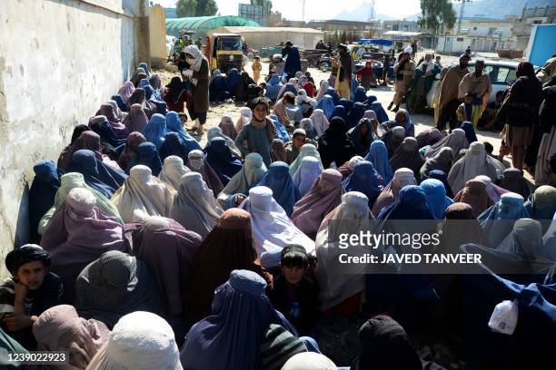 Women gather outside a United Nations High Commissioner for Refugees office as they wait to receive non-food items in Kandahar on March 8, 2022.