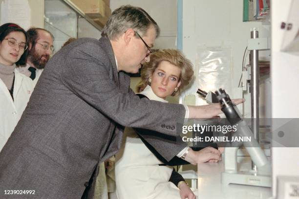 Britain's Princess Diana listens to the explanations of French Professor Luc Montagnier, on November 8, 1988 at Paris during her visit to the...