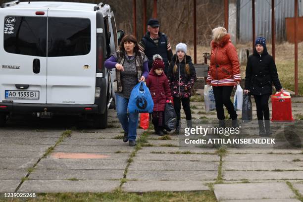 Family brings gifts in a school in Perekhrestya, close to the Ukrainian-Hungarian border on March 7 a refuge for 93 orphaned children evacuated from...