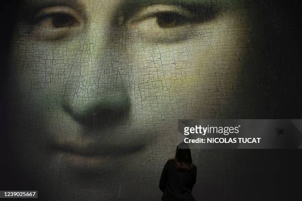 Visitor watches a giant screen showing a detail of Leonardo Da Vinci's portrait of Mona Lisa prior the opening of the exibition titled "La Joconde,...