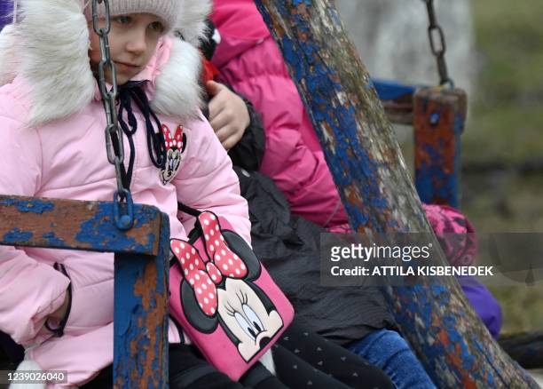 Young girl sits on a swing in the garden of a school in Perekhrestya, close to the Ukrainian-Hungarian border on March 7 a refuge for 93 orphaned...