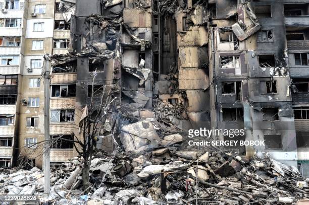 This picture shows an apartment building destroyed after shelling the day before in Ukraine's second-biggest city of Kharkiv on March 8, 2022. - The...