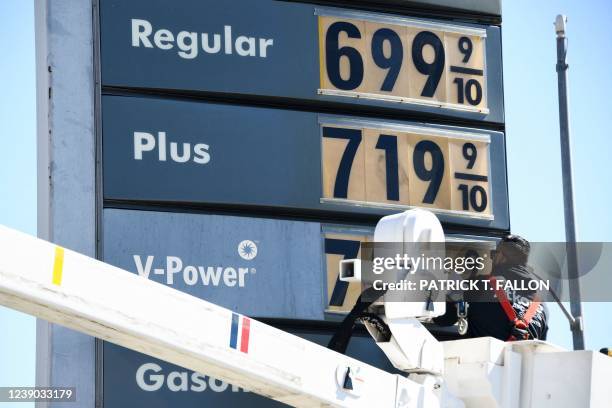 An electrical contractor repairs a sign with gasoline fuel prices above six and seven dollars a gallon at the Shell gas station at Fairfax and...