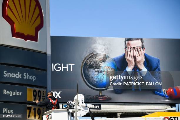 An electrical contractor repairs a sign with gasoline fuel prices above six and seven dollars a gallon at the Shell gas station at Fairfax and...