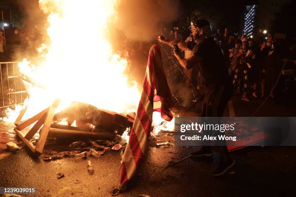 Demonstrators set a fire and burn a U.S. Flag during a protest near the White House on May 31, 2020 in Washington, DC. Minneapolis police officer...