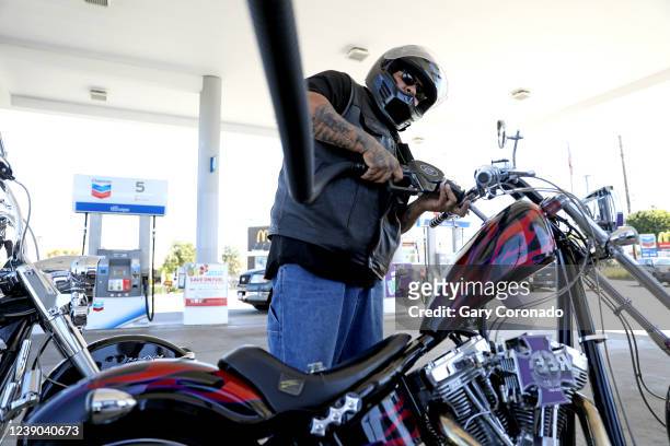 Mike Delgado, of Orange, pumps gas into his 2007 Swift 124 motorcycle at the Chevron gas station along Katella Ave. And Glassell on Tuesday, March 8,...