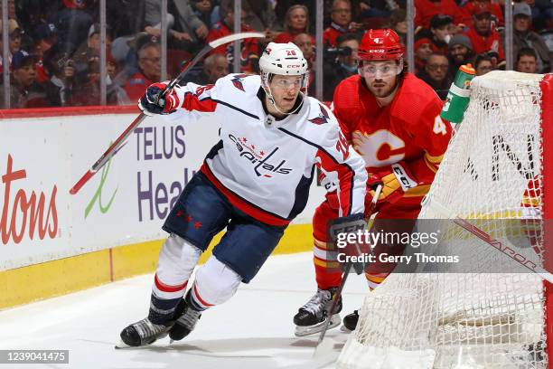 Rasmus Andersson of the Calgary Flames battles against Nic Dowd of the Washington Capitals at Scotiabank Saddledome on March 8, 2022 in Calgary,...
