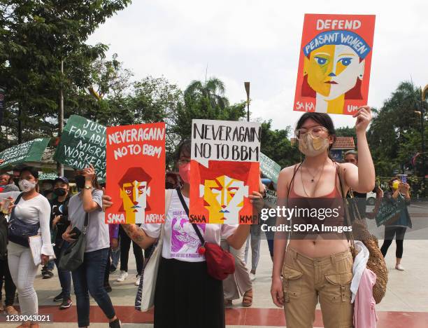 Young protesters hold placards, de-campaigning Presidential aspirant Ferdinand "Bongbong" Marcos Jr. And defending the peasant women during a...