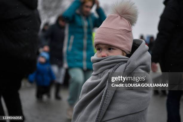 Child is wrapped in a blanket as Ukrainian refugees cross the border into Poland from Ukraine at the border crossing in Medyka, eastern Poland, on...