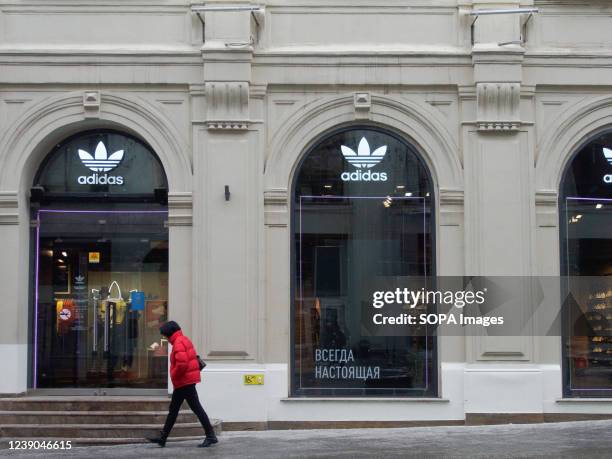 Man walks by an Adidas store. Adidas announced the imminent closure of business in Russia.