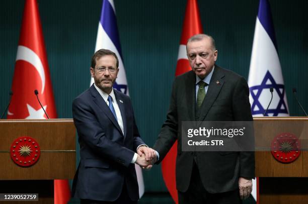 Israeli President Isaac Herzog and his Turkish counterpart Tayyip Erdogan shake hands during a press conference in Ankara, on March 9, 2022.