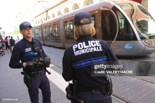 Des policiers municipaux patrouillent près d'un tramway le 25 avril 2010 à Nice, après que le maire UMP de la ville, Christian Estrosi, également...