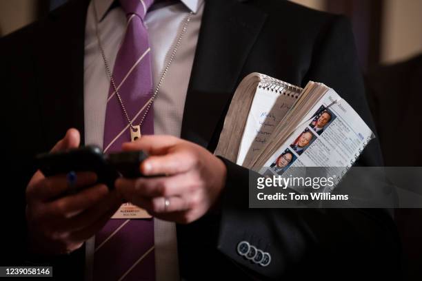 Reporter holds a members guidebook during a news conference with Senate Majority Leader Charles Schumer, D-N.Y., after the Senate luncheons in the...