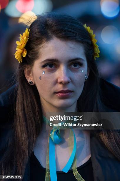 Woman with sunflowers in her hair reacts as Ukrainian people and their supporters protest in Trafalgar Square on the 14th day of Russian military...