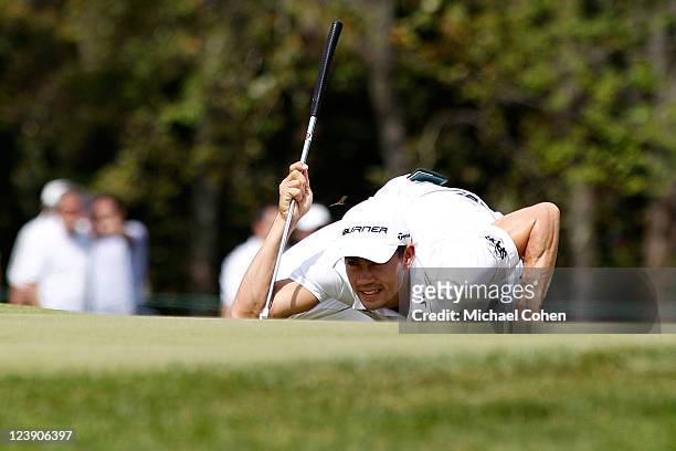 Bug hovers over the head of Camilo Villegas of Colombia as he reads the green prior to s putt attempt on the second hole during the final round of...