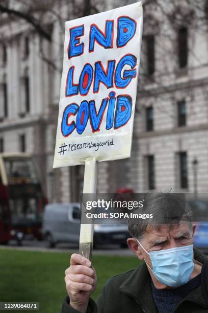 Protester holds up a placard demanding research and an end to Long Covid-19 during the demonstration. A protest group in Parliament Square demands...