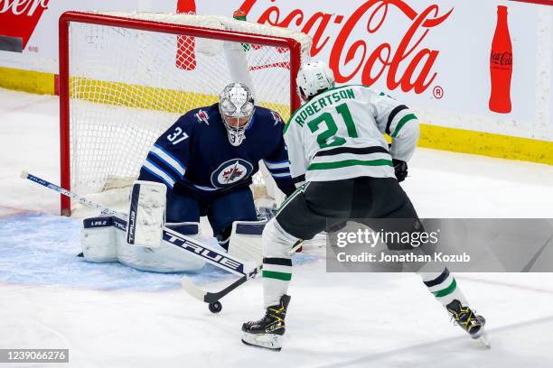 Jason Robertson of the Dallas Stars moves in for the shot against goaltender Connor Hellebuyck of the Winnipeg Jets during first period action at...