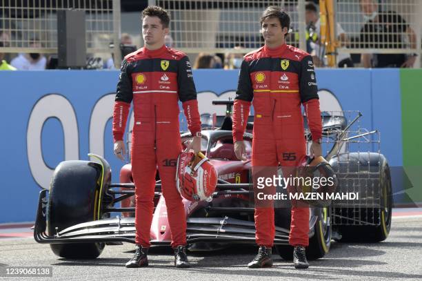 Ferrari's Monegasque driver Charles Leclerc and Ferrari's Spanish driver Carlos Sainz Jr pose in front of their car during the first day of Formula...