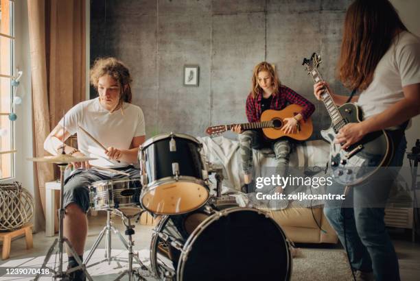 adolescente jugando rock and roll en casa - bandas-de-rock fotografías e imágenes de stock