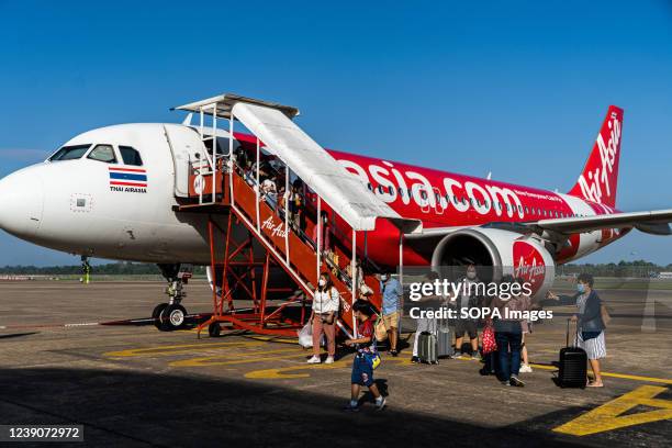 Passengers disembark from a Thai AirAsia flight at Surat Thani International Airport. Tourism resumes in Thailand after they ease the entry...