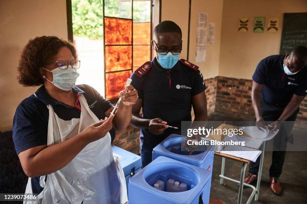 Health workers prepare doses of the Covid-19 vaccine during a rural vaccination drive by BroadReach Group, the public health implementation partner...