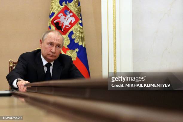 Russian President Vladimir Putin chairs a meeting with members of the Russian government via teleconference in Moscow on March 10, 2022. - Russia...