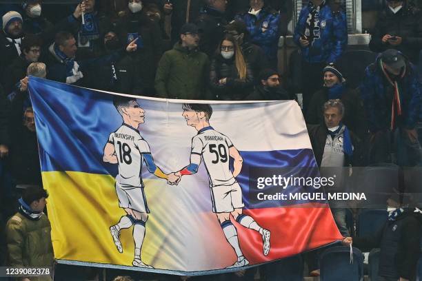 Fan's banner shows a figure of Atalanta's Ukrainian midfielder Ruslan Malinovskyi and Atalanta's Russian midfielder Aleksey Miranchuk shake hands,...