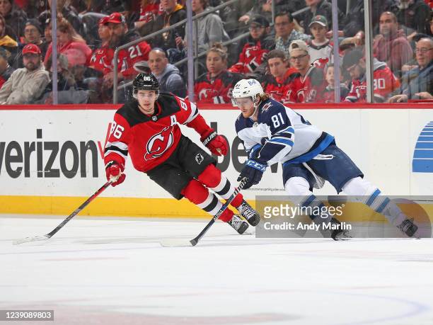 Kyle Connor of the Winnipeg Jets skates against Jack Hughes of the New Jersey Devils during the third period on March 10, 2022 at the Prudential...