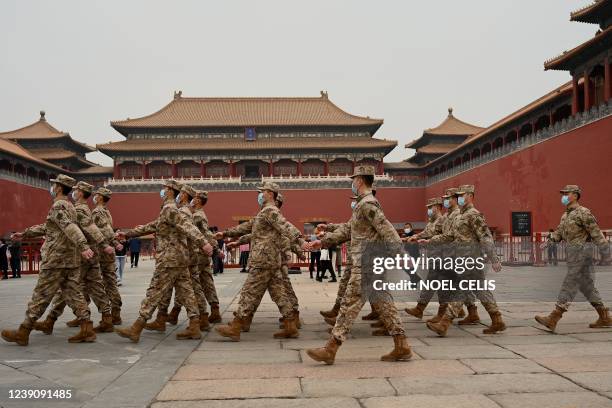 Security personnel march in front of the entrance to the Forbidden City as the closing session of the National Peoples Congress takes place at the...