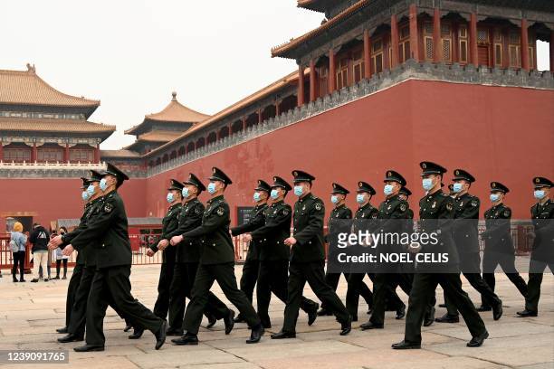 Security personnel march in front of the entrance to the Forbidden City as the closing session of the National Peoples Congress takes place at the...