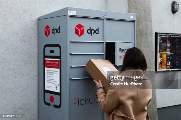 Woman uses DPD Pickup Station parcel locker in Krakow, Poland on March 10, 2022.