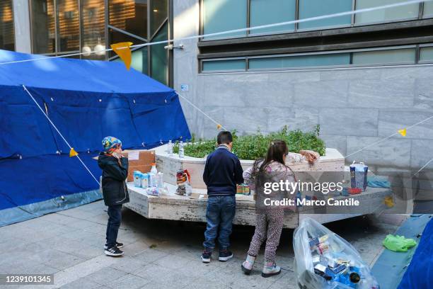 Ukrainian refugee children, fleeing the war in their country invaded by Russians, play while waiting for their parents in front of the Ukrainian...