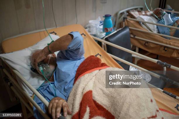 Two Iranian elderly men who are infected by COVID-19 use oxygen as they lie on hospital beds at a COVID-19 ward in a hospital in the holy city of Qom...