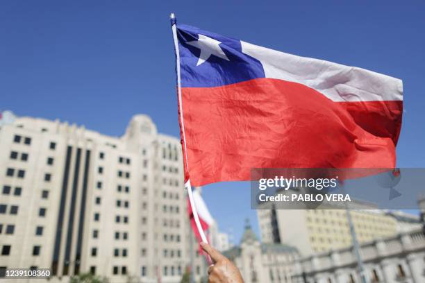 Supporter of Chile's new President Gabriel Boric holds a Chilean flag while waiting for his arrival to La Moneda Palace after his inauguration in...