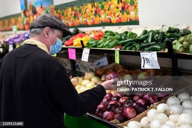 Customer browses produce at a stall inside Grand Central Market on March 11, 2022 in downtown Los Angeles, California. - US consumer prices hit a new...