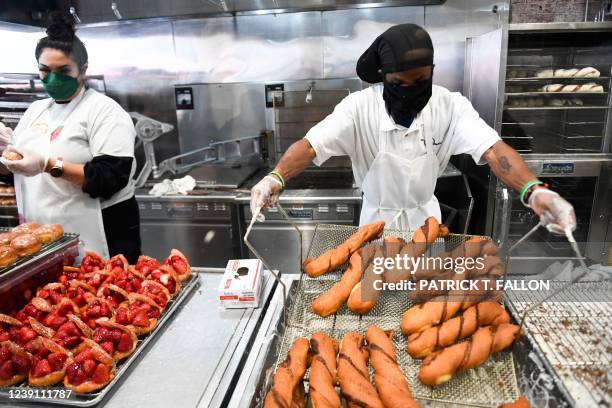 Workers make donuts and pastries at The Donut Man inside Grand Central Market on March 11, 2022 in downtown Los Angeles, California. - US consumer...