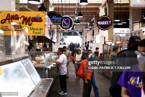 Customers walk near food stalls inside Grand Central Market on March 11, 2022 in downtown Los Angeles, California. - US consumer prices hit a new...