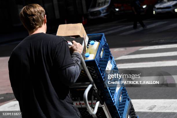 Worker delivers crates of milk from a delivery tuck to a store on March 11, 2022 in downtown Los Angeles, California. - US consumer prices hit a new...