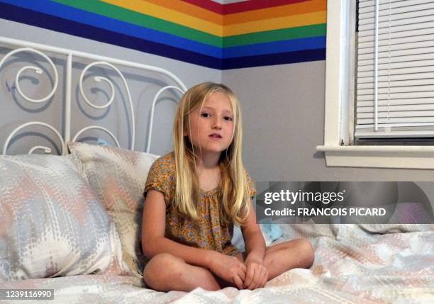 Sunny Bryant poses in her bedroom at her Houston, Texas, home on March 4, 2022. - Standing in front of a half-US, half-rainbow flag outside her home,...