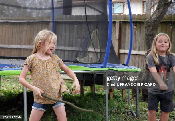 Sunny Bryant plays with brother, Bodhi, in the backyard of their Houston, Texas, home on March 4, 2022. - Standing in front of a half-US,...